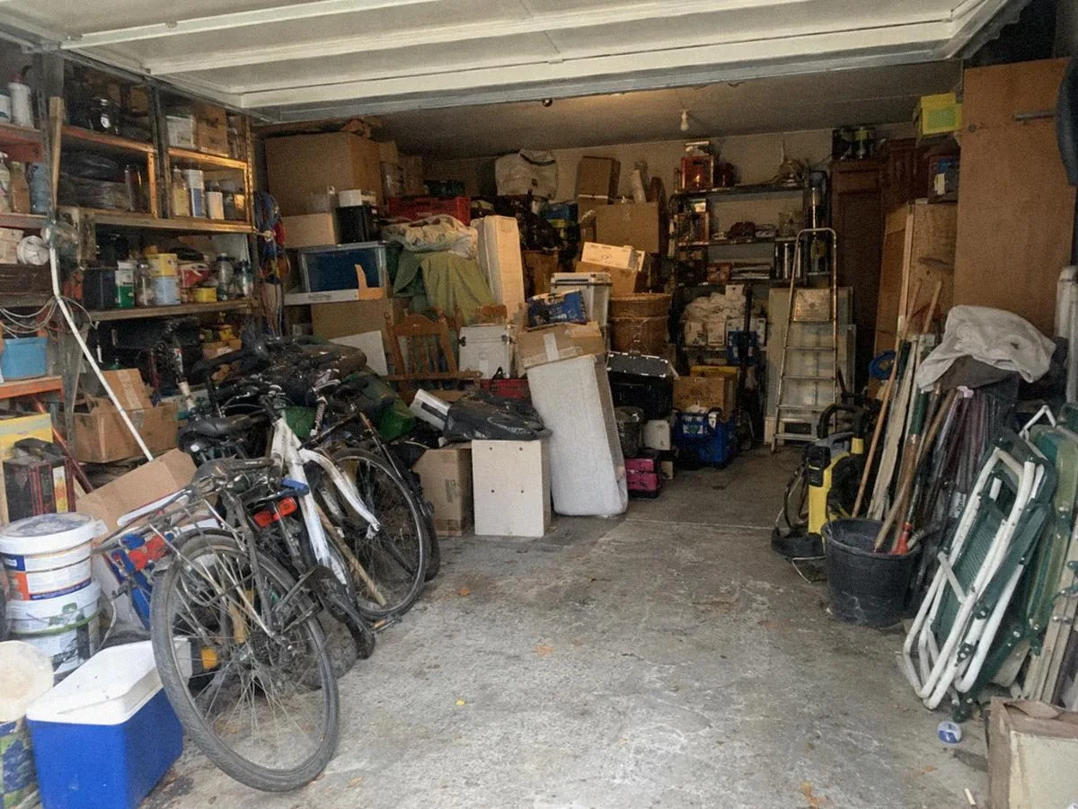 Garage rempli de cartons et d'objets, avant le débarras
